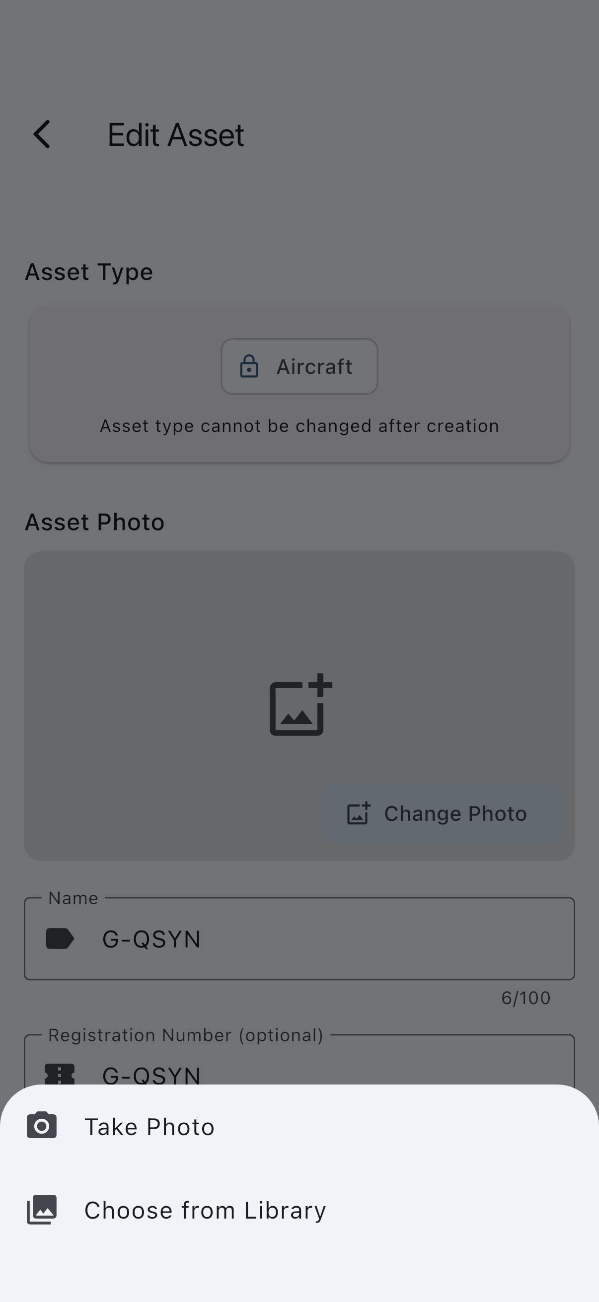 The Edit Asset screen with the Asset Photo section near the top, its Change Photo button, and the source picker offering the camera or the photo library
